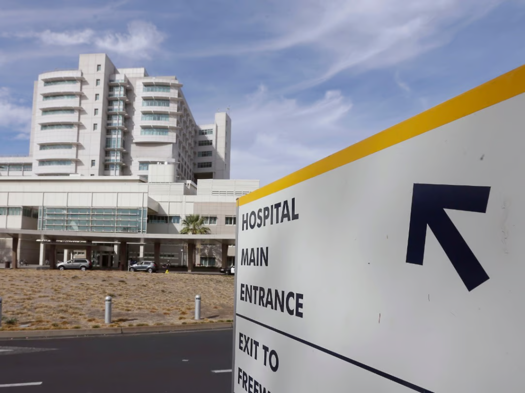 A sign at UC Davis Med Center, with the Med Center building in the background.