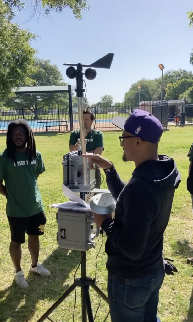 A Green Team facilitator training volunteers to use an air monitor.